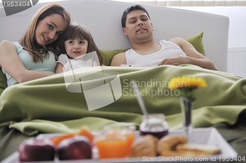 Image of happy young family eat breakfast in bed