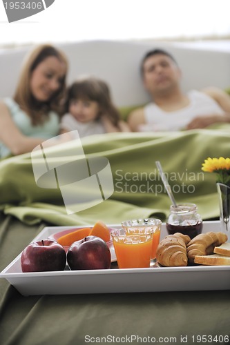 Image of happy young family eat breakfast in bed