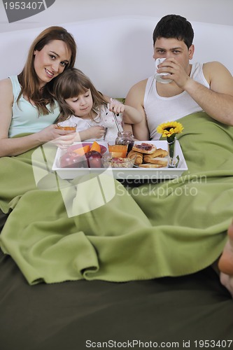 Image of happy young family eat breakfast in bed