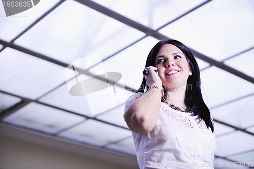 Image of young happy business woman talking by cellphone