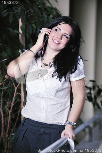 Image of young happy business woman talking by cellphone