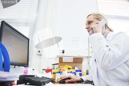 Image of pharmacy worker talking by phone