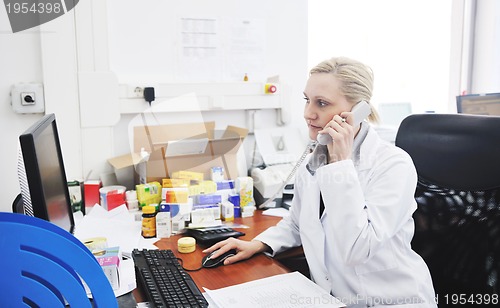 Image of pharmacy worker talking by phone