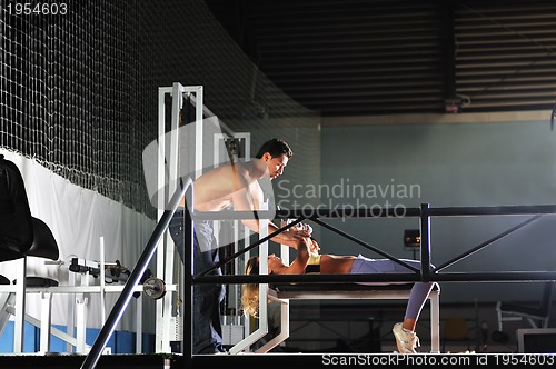 Image of woman in the fitness gim working out with personal trainer