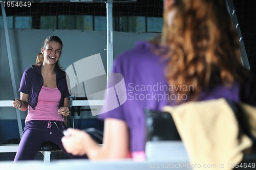 Image of young woman relaxing from working out in a gym 