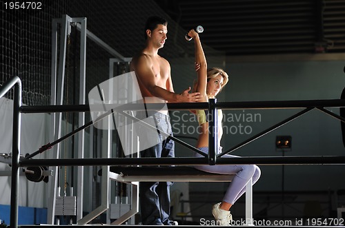 Image of Young woman in gym with coach