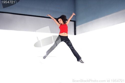 Image of young woman jumping indoor