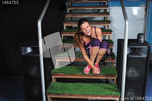 Image of young woman smiling on green stairs