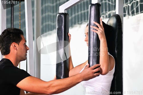 Image of woman in the fitness gim working out with personal trainer