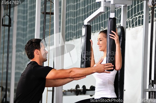 Image of woman in the fitness gim working out with personal trainer