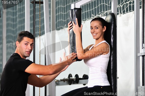 Image of woman in the fitness gim working out with personal trainer