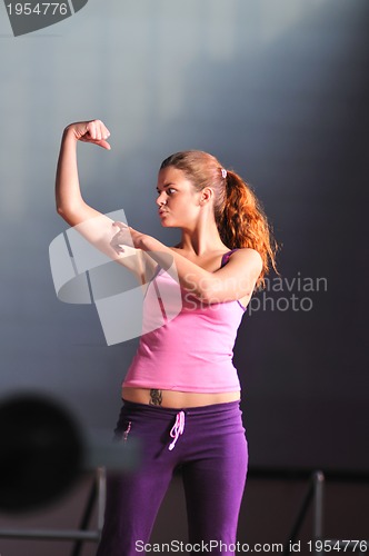 Image of young woman with strong arms rising hands in air