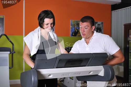 Image of Young woman in gym with coach