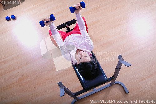 Image of .a young woman weightlifting at gym 