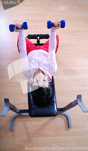 Image of .a young woman weightlifting at gym 