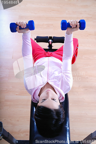 Image of .a young woman weightlifting at gym 