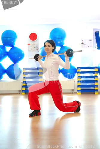 Image of .a young woman weightlifting at gym 