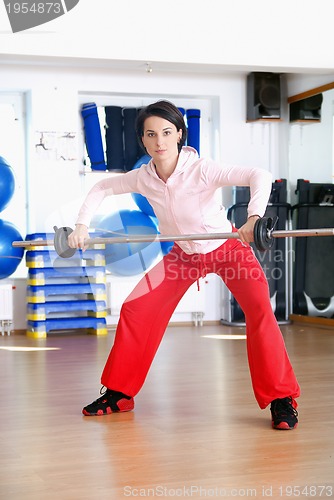Image of .a young woman weightlifting at gym 