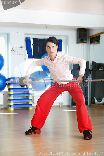 Image of .a young woman weightlifting at gym 