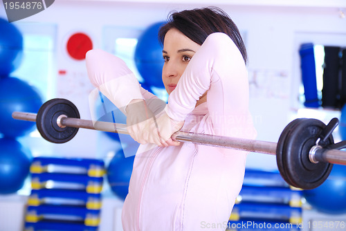 Image of .a young woman weightlifting at gym 