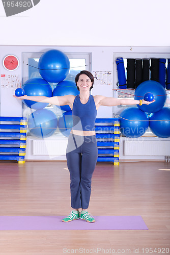Image of .happy young woman exercising in a gym