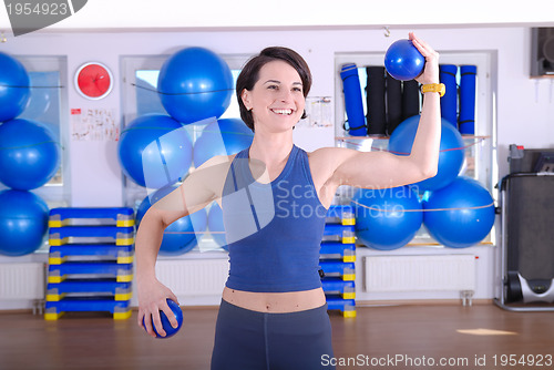 Image of .happy young woman exercising in a gym