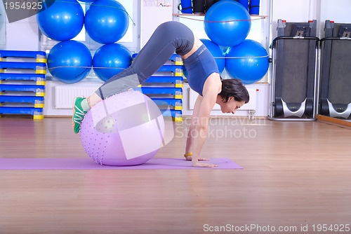 Image of .happy young woman exercising in a gym