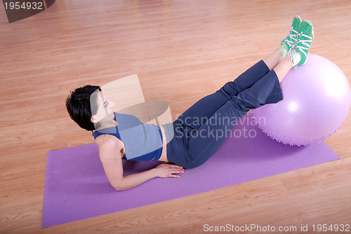 Image of .happy young woman exercising in a gym