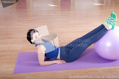 Image of .happy young woman exercising in a gym