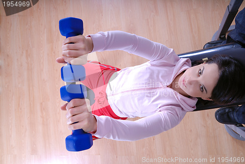 Image of .a young woman weightlifting at gym 