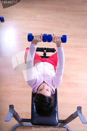 Image of .a young woman weightlifting at gym 