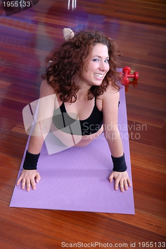 Image of young pretty woman exercising in a fitness center