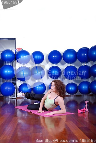 Image of young pretty woman exercising in a fitness center