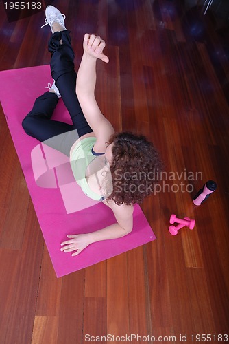Image of young pretty woman exercising in a fitness center