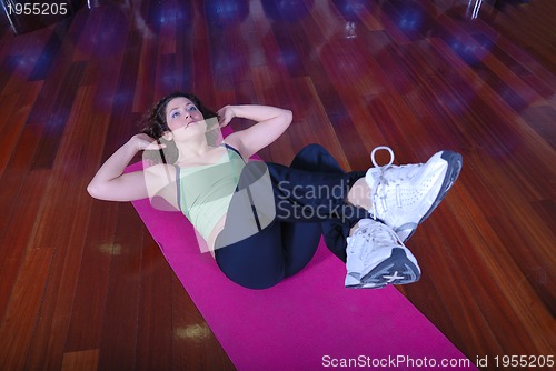 Image of young pretty woman exercising in a fitness center