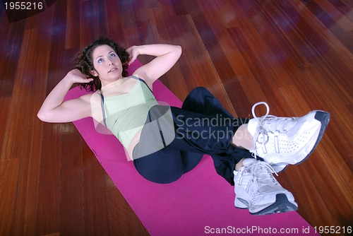 Image of young pretty woman exercising in a fitness center