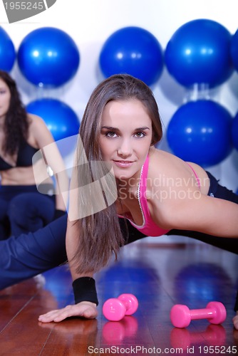 Image of young pretty woman exercising in a fitness center