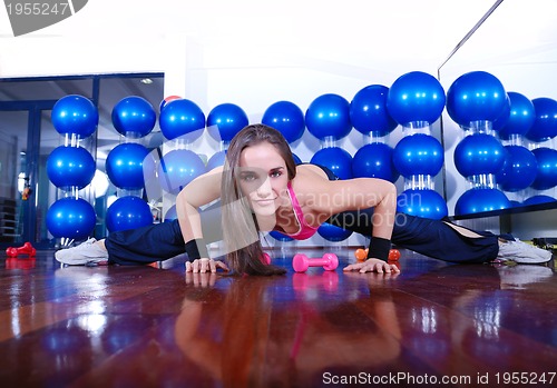 Image of young pretty woman exercising in a fitness center