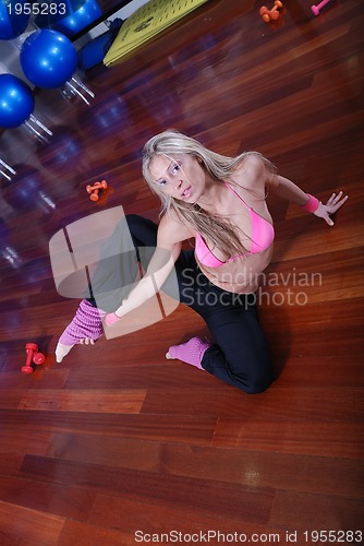 Image of young pretty woman exercising in a fitness center