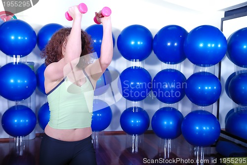 Image of young pretty woman exercising in a fitness center