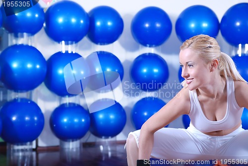 Image of young woman exercising with pilates ball