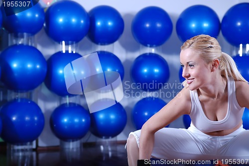 Image of young woman exercising with pilates ball