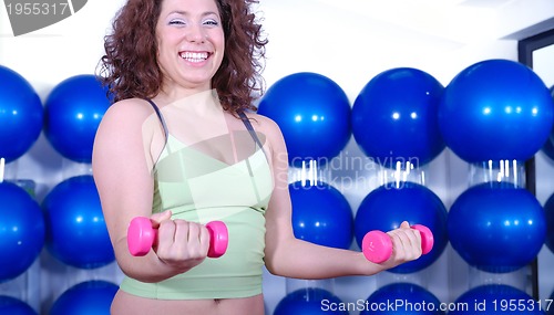 Image of young pretty woman exercising in a fitness center