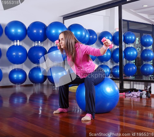Image of young pretty woman exercising in a fitness center