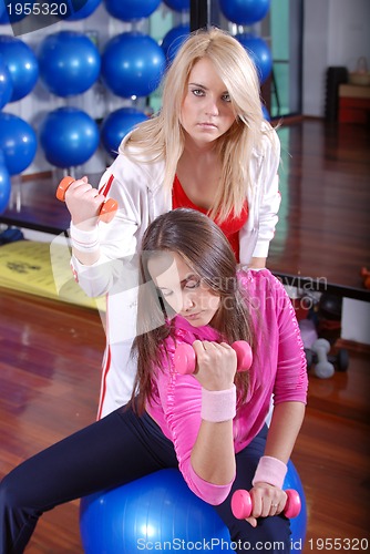 Image of young pretty woman exercising in a fitness center