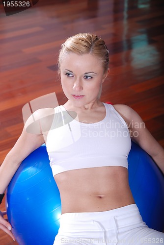 Image of young woman exercising with pilates ball