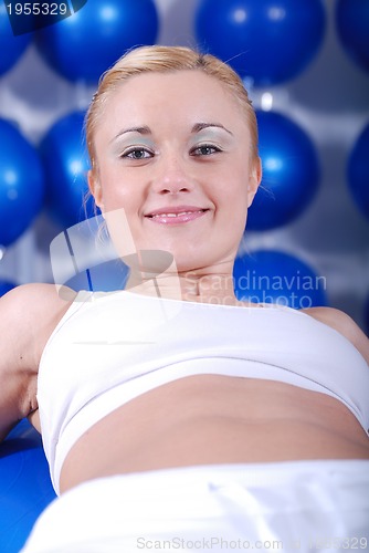 Image of young woman exercising with pilates ball