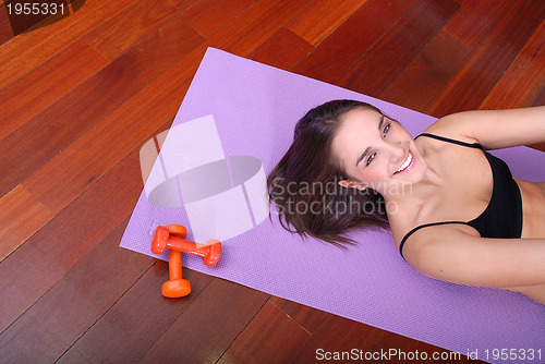 Image of young pretty woman exercising in a fitness center