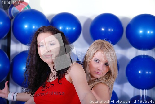 Image of two happy girls in fitness studio