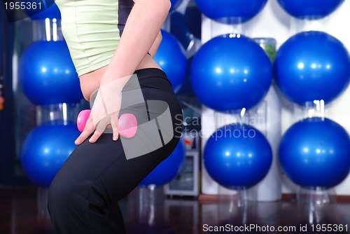 Image of young pretty woman exercising in a fitness center